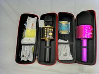 Two wireless microphones inside individual black and red carrying cases, with accessories and manuals included.