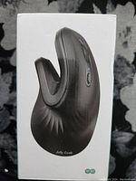 Front view of the black Jelly Comb wireless vertical mouse on product box background, showing ergonomic shape with thumb rest and buttons.