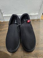 Top view of men's black slip-on canvas shoes, new size 12, showing the pair from above.