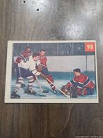 Front of 1954 Parkhurst hockey card #98 showing Jacques Plante in action against other players on ice.