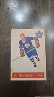 Front side of 1957 Parkhurst hockey card featuring Mike Nykoluk with Toronto Maple Leafs uniform, card number 16.