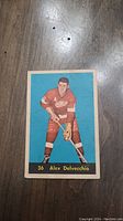 Front of the 1960 Alex Delvecchio Parkhurst hockey card showing the player in red uniform with stick, number 36 and name.