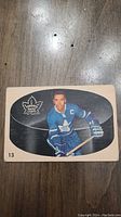 Front of 1962 George Armstrong Parkhurst hockey card showing image of player in Toronto Maple Leafs uniform with captain's C and card number 13