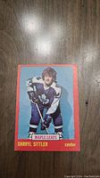 Front view of the 1973 Darryl Sittler O-Pee-Chee hockey card showing the player in Maple Leafs uniform with red border.