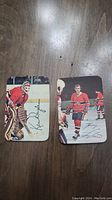 Front photo of two 1977 OPC hockey cards featuring Ken Dryden in goalie gear and Guy Lafleur in uniform with facsimile autographs.