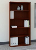 Photo of a tall wooden bookcase with five shelves in a dark wood finish, decorated with binders, books, and two vases.