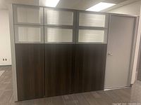 Front view of modular office wall panel with three sections, frosted glass upper panels, and a door on the right side.