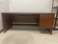 Front view of the rectangular office desk showing two drawers on the right and keyboard tray underneath.