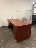Side view of modern office desk showing wood finish, drawer on left side, and smooth surface.