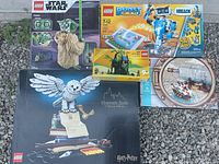 Overview of five LEGO boxes on gravel: Hogwarts Icons, Yoda, Boost Creative Toolbox, Forest Hideout, circular diorama box