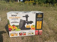 Box of Ninja Cold Press Juicer 790 showing front view with images of juice pouring from the juicer and fruits around.