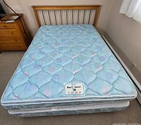 Bed with blue floral quilted mattress labeled 'Back Saver', viewed from above