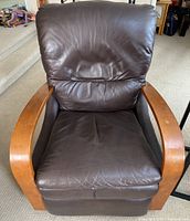 Front view of the brown leather La-Z-Boy recliner showing the seat, backrest, and wooden arms.