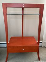 Front view of the wooden cabinet showing the drawer and glass shelf.