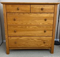 Front view of wooden dresser showing five drawers and overall condition