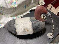 Top side view showing painted black, white and brown duck decoy body with attached lead weight on string