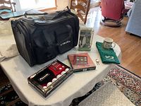 Photo showing all golf gift items on a table including black LivLabs shoe bag, golf balls in Puma box, golf tic tac toe game, towel, and mug.