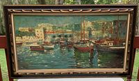 Full view of the framed oil painting showing a harbour scene with boats and buildings.
