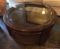 Overhead view of round coffee table showing beveled glass inset and wood rim