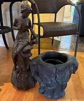 Composite figurine of a woman and elephant-shaped planter placed on floor showing size and shape