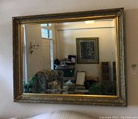 Full view of large rectangular mirror mounted on wall reflecting living area