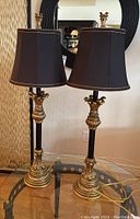 Full view of both lamps on glass table with round mirror in background