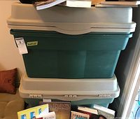 Four stacked green storage totes with beige lids. Close-up view shows the sturdy rectangular shape and lid fitment. Totes appear in good condition and are empty as per seller description.