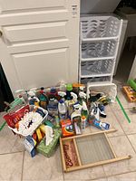 Photo showing all items including the washboard, multiple bottles of cleaning products, a plastic white storage shelf unit with four drawers, and cleaning tools.