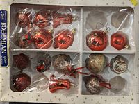 Full view of vintage Bohemian glass ornaments set in original packaging with 15 diverse ornaments in red and gold tones.