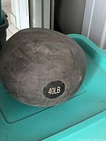 Front side view of the black exercise ball labeled 40LB showing worn surface.