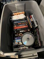 Photo showing the media bin with DVDs, VHS tapes, blank DVDs, and CDs visible.