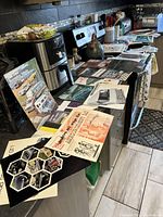 Overview of the collection spread out on kitchen counter showing various vintage automobile papers, brochures, and promotional materials from the 1940s-1970s.