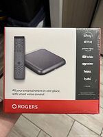 Front view of the sealed Rogers streaming device box showing the product image and compatible streaming services.