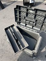 Open plastic toolbox showing removable tray with divided compartments for tools and hardware