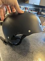 Side view showing smooth matte black finish and adjustable chin strap.