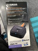 Front view of Yamaha YBA-11 Bluetooth Wireless Audio Receiver box showing product image and branding.