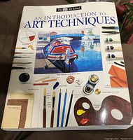 Front cover of 'The DK Art School: An Introduction to Art Techniques' book showing the title, authorship, and illustrations of art supplies and scenic artwork.