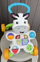 Front view of Fisher-Price zebra-themed baby walker showing interactive buttons, music, and colorful design.