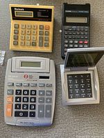 Four calculators arranged showing the top view and layout of each calculator.