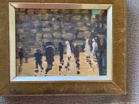 Front view of framed painting depicting figures before a wall under glass in golden frame.