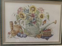 Full view of the framed watercolor-style print showing a watering can with flowers, plums, small pots, robin bird, and cherries in basket on cloth.
