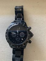 Front view of black Toy Watch chronograph wristwatch showing black dial with sub-dials and textured bracelet.