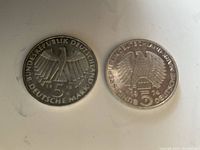 Photo of two German silver 5 Deutsche Mark coins showing the eagle and denomination.