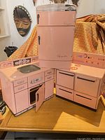 Three-piece set displayed together: fridge, stove, sink cabinet