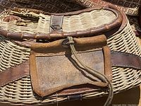 Close-up view of creel front with leather flap secured by cord.