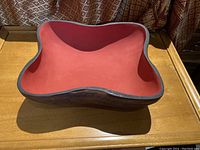 Top view showing the carved bowl's red painted interior and organic shape.