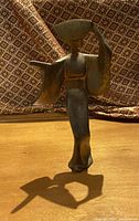 Full standing view of Japanese bronze figure on wooden surface