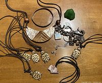 Lot of jewelry including owl necklaces, carved Buddha pendant, earrings, and charm chain