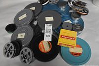 Wide shot of assortment of vintage metal Kodak film canisters, assorted film reels, and Kodachrome II film boxes.
