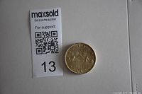 Photo of Canadian silver dollar coin placed next to lot number and QR code